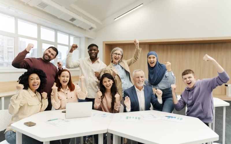 Group of overjoyed multiracial business people using laptop celebration success, win money, working together in modern office. Portrait happy startup team meeting. Successful business concept S